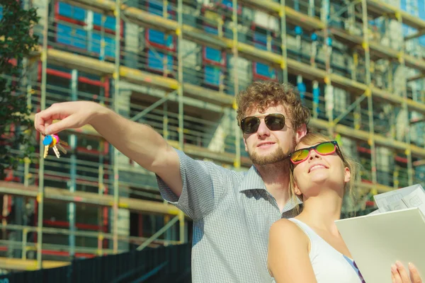 Pareja en frente de casa nueva con proyecto de anteproyecto — Foto de Stock