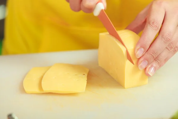 Manos de mujer cortando trozo de queso —  Fotos de Stock