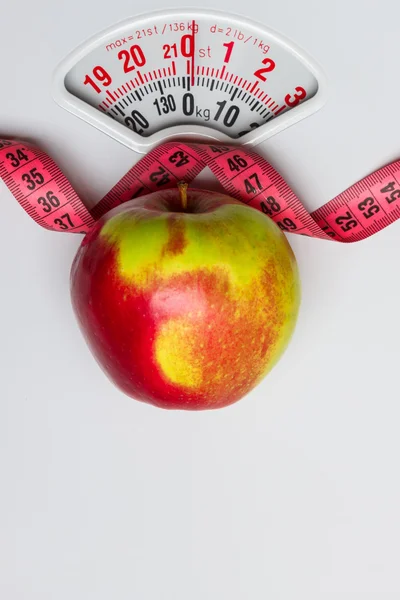 Apple with measuring tape on weight scale. Dieting — Stock Photo, Image