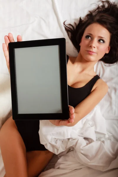 Sexy lazy girl lying with tablet touchpad on bed — Stock Photo, Image
