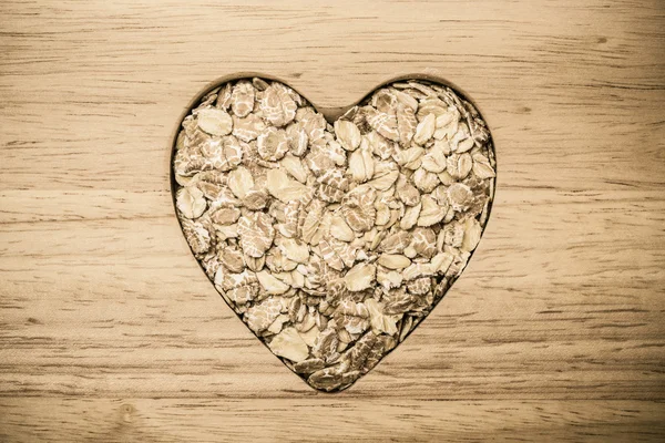 Cuore di avena a forma di cereale su superficie di legno . — Foto Stock