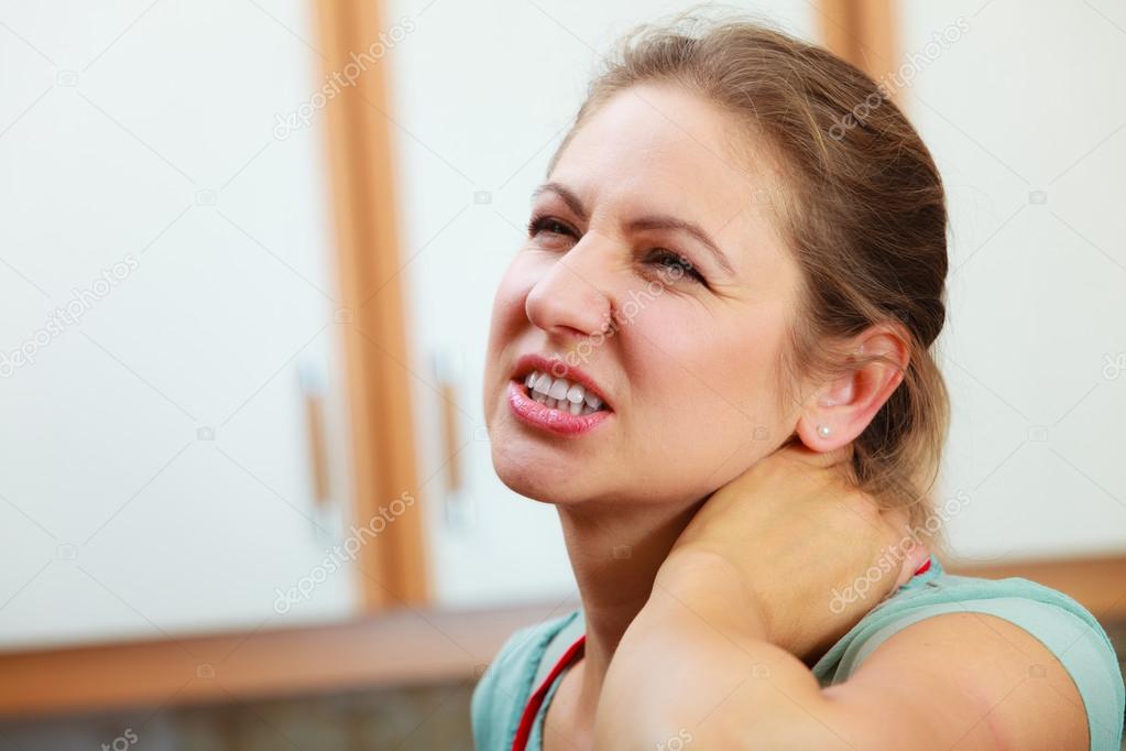 Overworked woman suffering from neck pain.