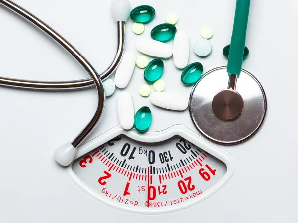 Comprimidos e estetoscópio em escalas. Serviços de saúde — Fotografia de Stock