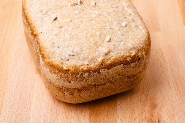 Ahşap arka planda bir somun ekmek — Stok fotoğraf