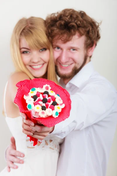 Glückliches Paar mit Süßigkeiten Strauß Blumen. Liebe. — Stockfoto