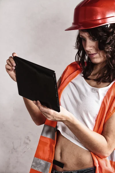 Ragazza sexy in casco di sicurezza utilizzando tablet touchpad — Foto Stock