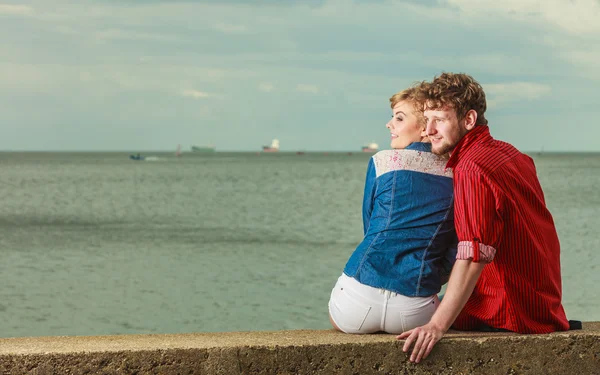 Par sittande kramade vid havets strand — Stockfoto