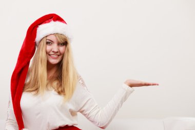 Woman in santa hat with empty hand for copy space