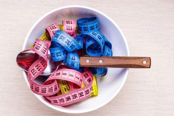 Muchas cintas métricas coloridas en tazón en la mesa —  Fotos de Stock
