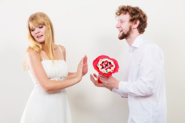 Adam şeker demet çiçek üzgün kadın için veriyor..