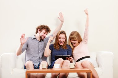 Evde tablet ile başarılı mutlu arkadaşlar.