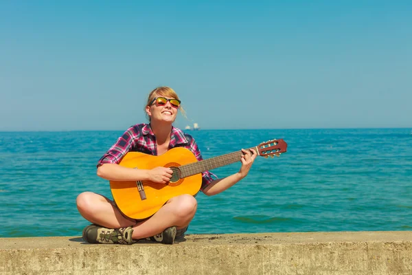 Ung kvinna med gitarr utomhus — Stockfoto