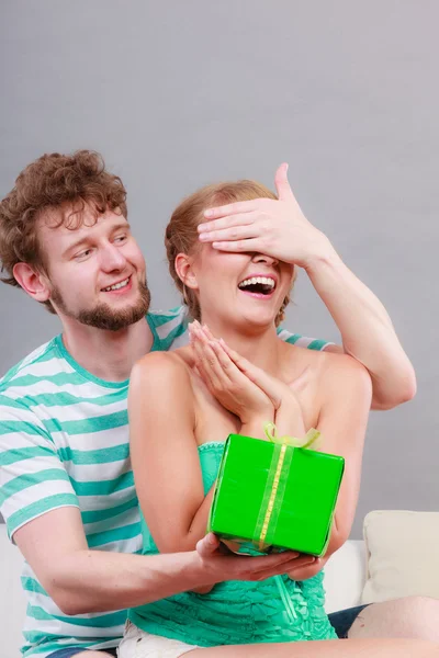 Young man giving woman gift box — Stock Photo, Image