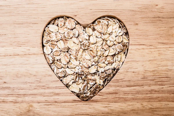 Cuore di avena a forma di cereale su superficie di legno . — Foto Stock