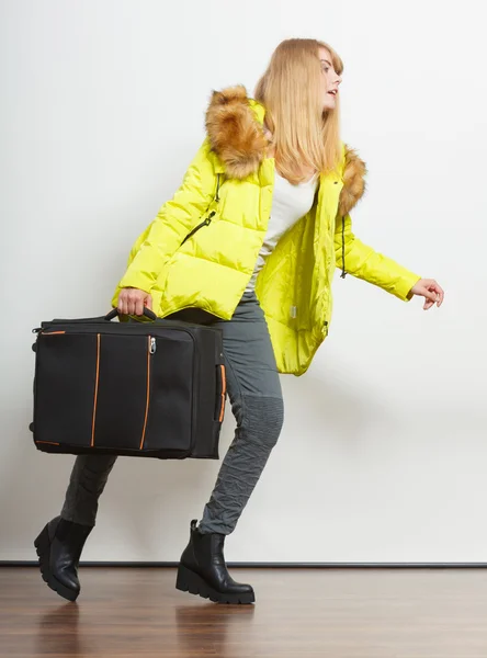 Junge Frau in warmer Jacke mit Koffer. — Stockfoto