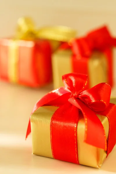 Small red and golden boxes with gifts tied bows Stock Image