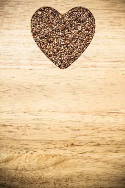 Ve tvaru srdce lněný surového lněného semínka — Stock fotografie