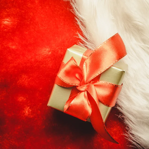 Küçük altın kutu hediye ile kırmızı yay bağlı — Stok fotoğraf