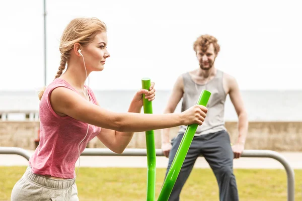 Homme et femme faisant de l'exercice sur un entraîneur elliptique . — Photo