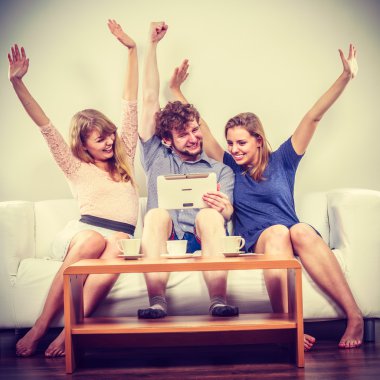 Evde tablet ile başarılı mutlu arkadaşlar.