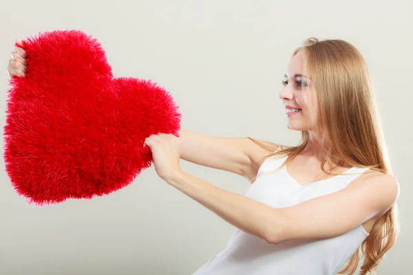 Mujer sosteniendo corazón en forma de almohada símbolo de amor — Foto de Stock