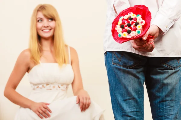 Mann überreicht Frau Bonbonstrauß Blumen. Liebe. — Stockfoto