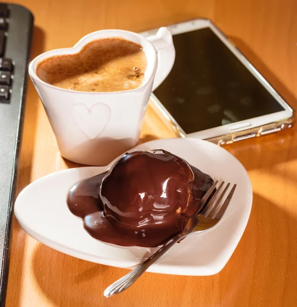 Copa de café y pastel de chocolate al lado de la computadora . — Foto de Stock