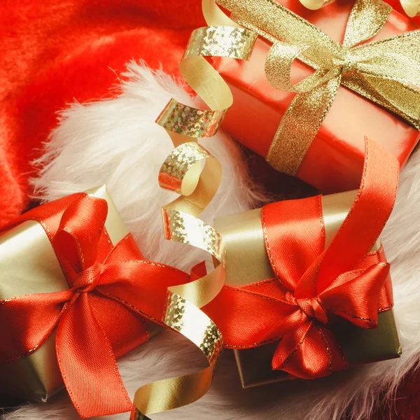 Küçük kırmızı ve altın kutular hediye ile yay bağlı — Stok fotoğraf