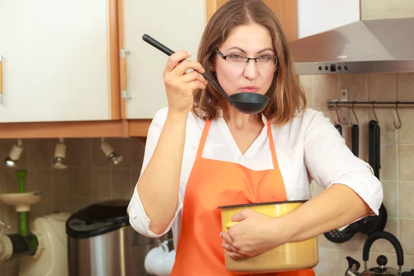 Mulher com concha e panela na cozinha — Fotografia de Stock