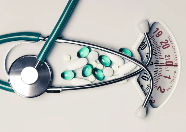 Tabletták és sztetoszkóp, a mérleg. Egészségügyi ellátás — Stock Fotó