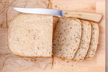 Kepekli ekmek kesme tahtası üzerinde dilimlenmiş