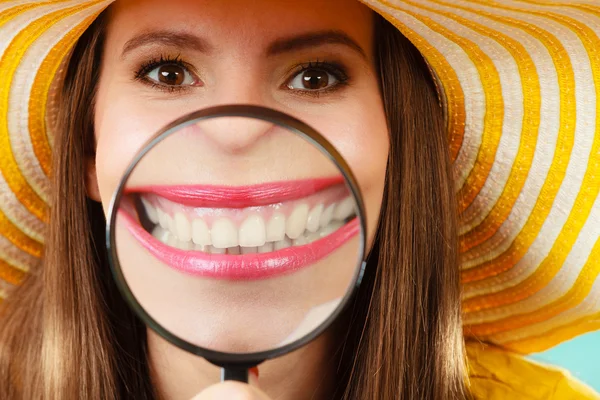 Funny woman show teeth through magnifying glass — Stockfoto