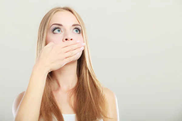 Verbaasd vrouw die betrekking hebben op haar mond met de hand — Stockfoto