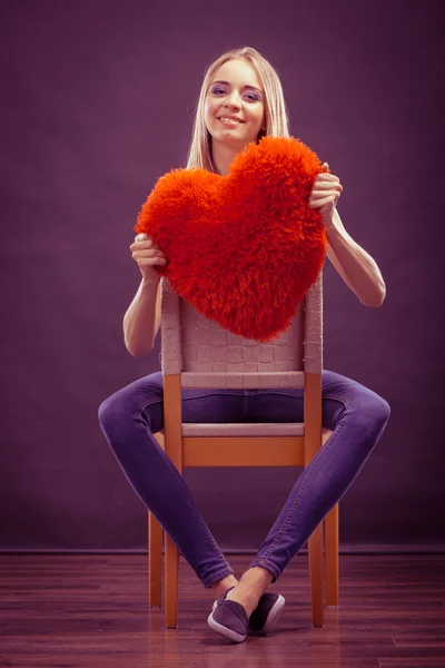 Mujer sosteniendo corazón en forma de almohada símbolo de amor — Foto de Stock