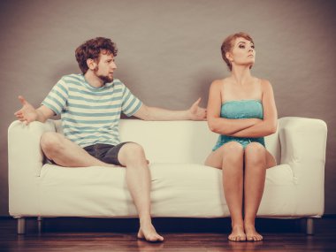 Man and woman in disagreement sitting on sofa clipart
