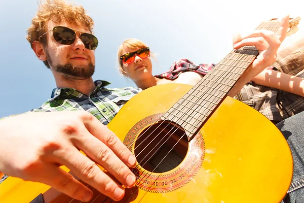 Joven hipster tocando la guitarra para mujer . — Foto de Stock