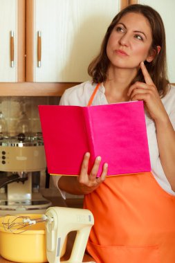 Mutfakta yemek kitabı ile ev hanımı.