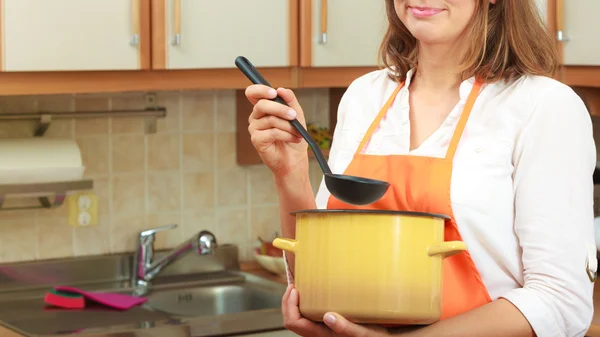 Frau mit Schöpfkelle und Topf in Küche — Stockfoto
