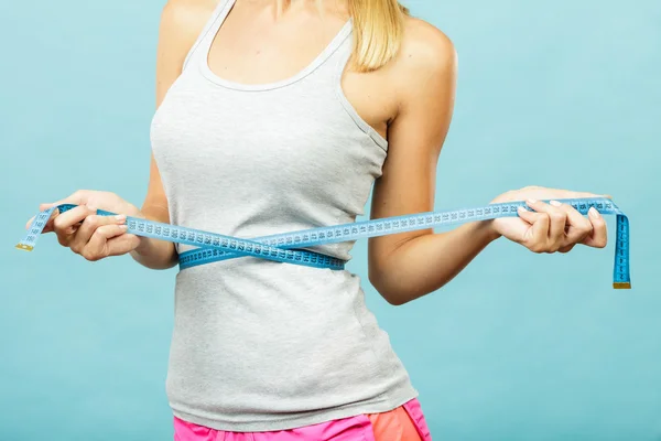 Fitness girl measuring her waistline — Stock Photo, Image