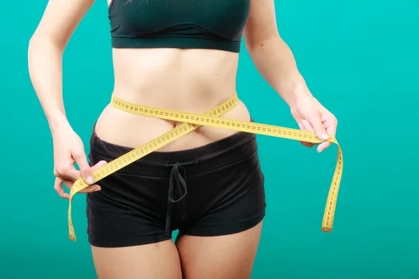 Fitness girl measuring her waistline — Stock Photo, Image