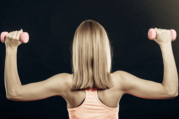 Fitness sporty girl lifting weights back view