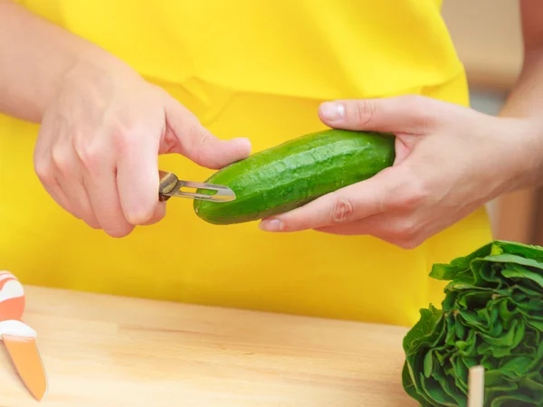 Donna che prepara verdure insalata peeling cetriolo — Foto Stock