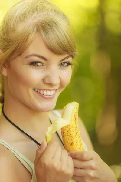 Tourist woman eating banana fruit in forest trail — Stock Photo, Image