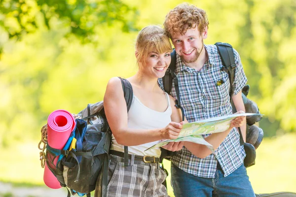 Senderismo mochilero pareja lectura mapa en viaje . — Foto de Stock