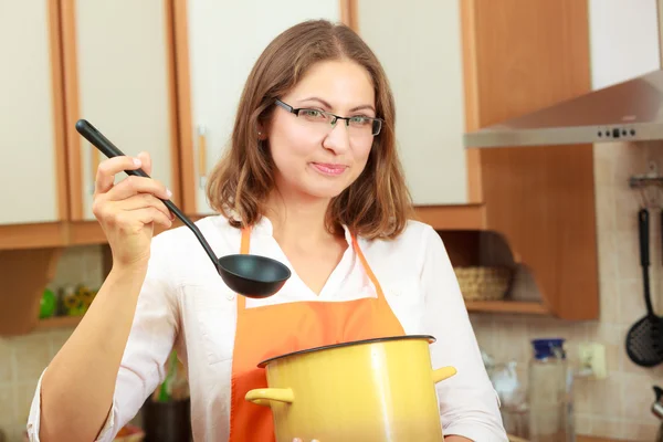 Femme avec louche et pot dans la cuisine — Photo