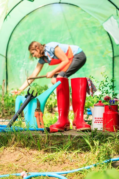 Perempuan petani dan alat berkebun di kebun — Stok Foto