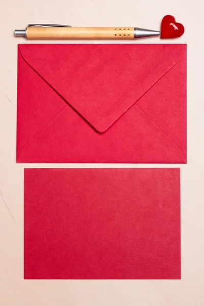 Leeres rotes Papier und Umschlag auf dem Tisch — Stockfoto