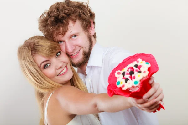 Glückliches Paar mit Süßigkeiten Strauß Blumen. Liebe. — Stockfoto