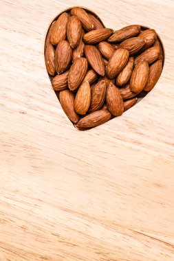Badem ahşap yüzey zemin üzerinde kalp şeklinde