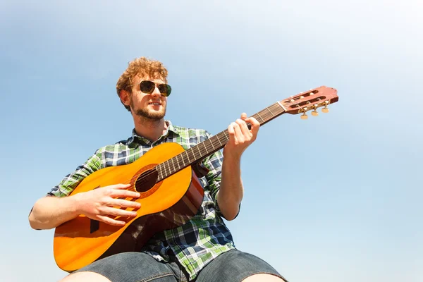 Jonge man hipster gitaarspelen. — Stockfoto